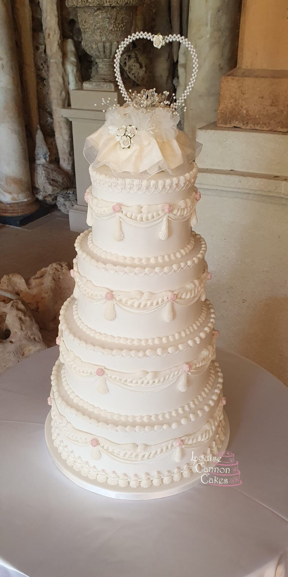 Four tier vintage wedding cake with hand piped royal icing decorations displayed in the alcove at Euridge Manor exclusive use wedding venue.