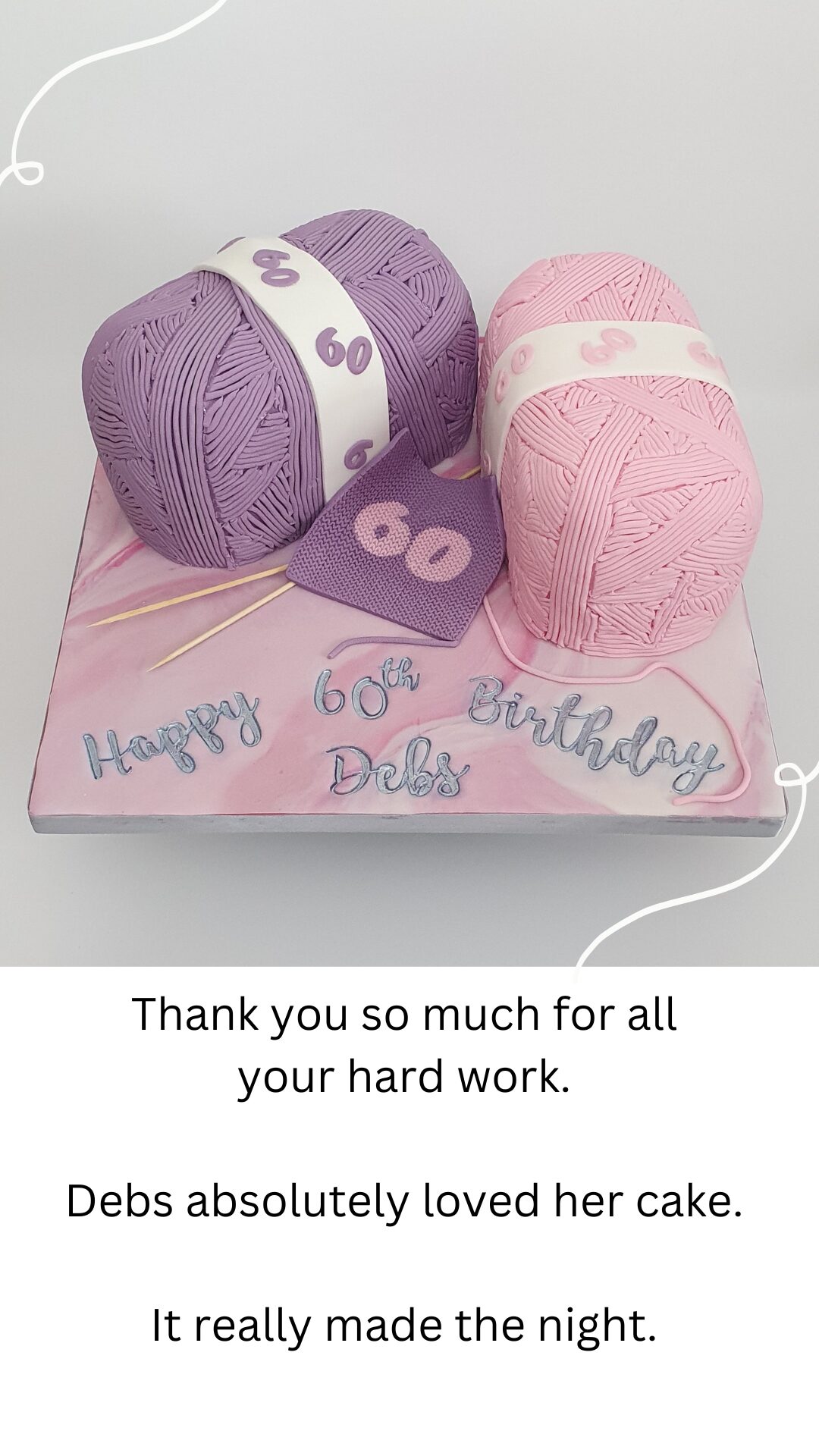 Carved 60th birthday cake in the shape of two balls of wool. With pink and lilac wool and a knitted 60th birthday patch on wooden needles. Presented on a square board with pink and white marbled icing. 